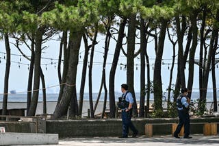 Members of the police patrol along the coast after people were advised to leave coastal regions as much of coastal Japan went on alert